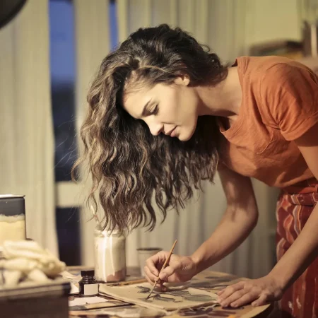 creative female artisan drawing in workshop